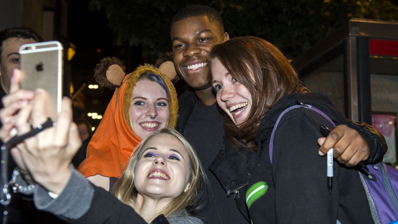 Actor John Boyega, who will be starring in the new "Star Wars" movie later this year, takes a photo with fans in London on Friday, September 4.