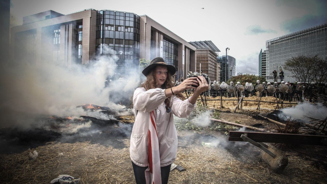 A girl takes a selfie during a farmers demonstration in Brussels, Belgium, on Monday, September 7. Thousands of angry European farmers set off fireworks, blared horns and blocked streets with tractors as they demanded emergency European Union funds to help them cope with plunging food prices and soaring costs.