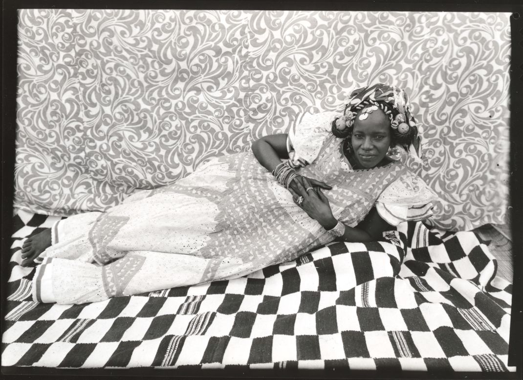 According to Biro, this woman poses in a relaxed way as to display her sociability and better show off her elegant dress.<br /><br />Reclining Woman, 1950s-1960s<br />Seydou Keita (Malian, 1921/23 -- 2001)<br />Gelatin silver print, 1975