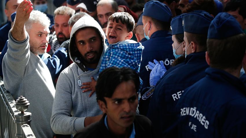 BUDAPEST, HUNGARY - SEPTEMBER 09:  A young Syrian boy cries as his father carries him past Hungarian police after being caught in a surge of migrants attempting to board a train bound for Munich, Germany at the Keleti railway station on September 9, 2015 in Budapest, Hungary. Migrants in Budapest are concerned that governments will soon close or severely limit continued travel access to Austria and Germany. Since the beginning of 2015 the number of migrants using the so-called 'Balkans route' has exploded with migrants arriving in Greece from Turkey and then travelling on through Macedonia and Serbia before entering the EU via Hungary. The number of people leaving their homes in war torn countries such as Syria, marks the largest migration of people since World War II.  (Photo by Win McNamee/Getty Images)