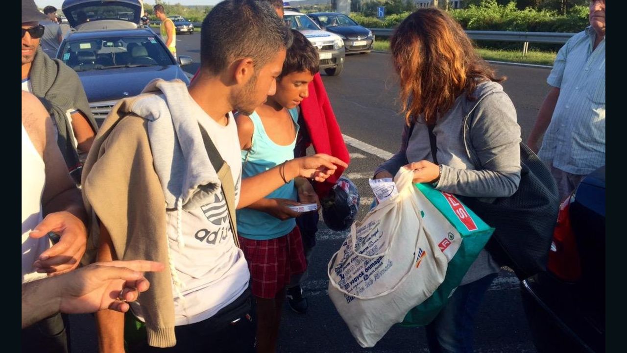 Ordinary Hungarians stop on the highway to hand out food and water to refugees.