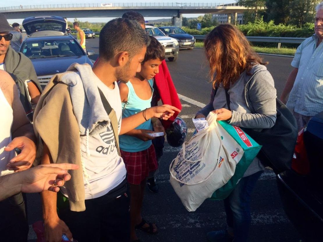 Ordinary Hungarians stop on the highway to hand out food and water to refugees.