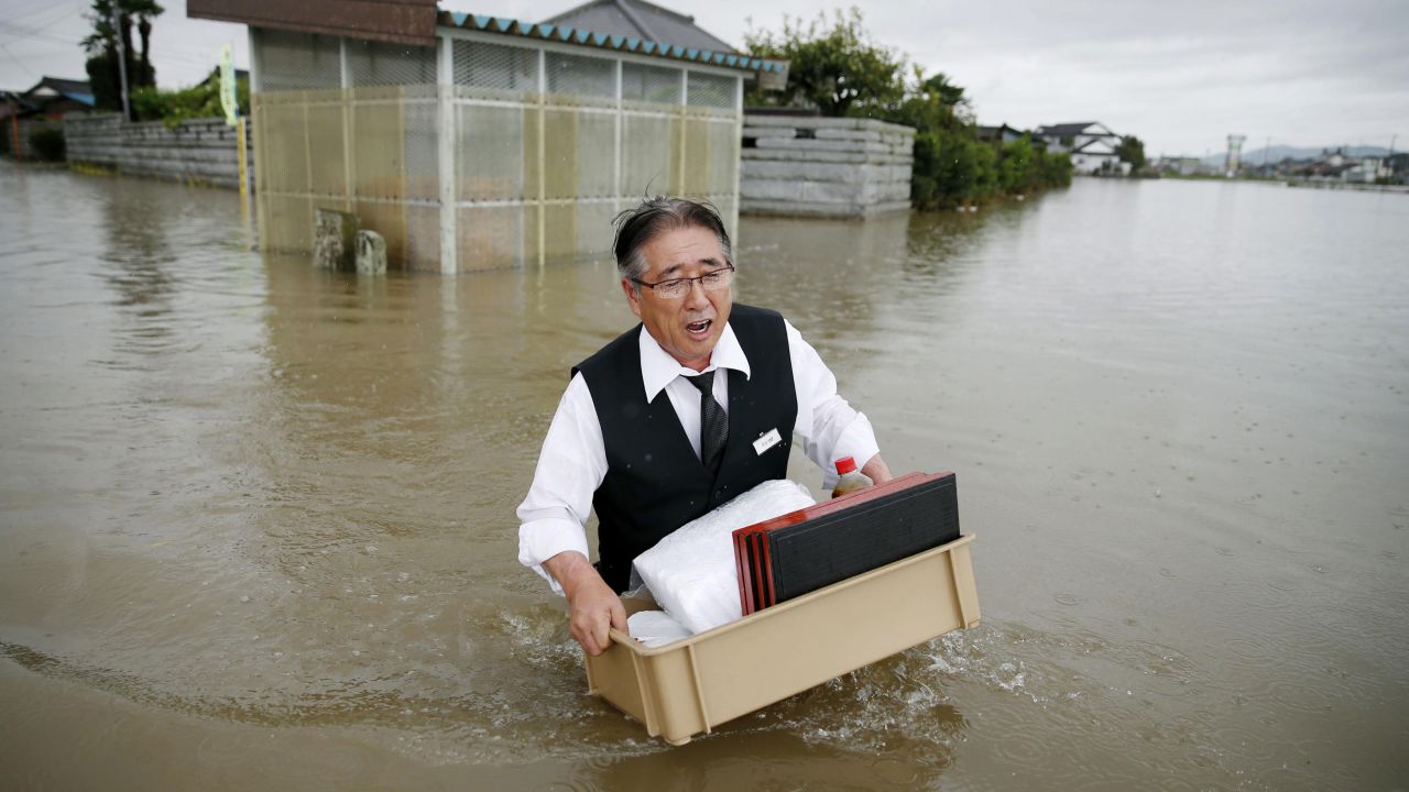 A man wades through a flooded street in Oyama, Japan, on Thursday, September 10, after heavy rain pounded the region for two straight days.