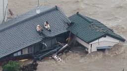 Local residents wait to be rescued on the roof of their home in a flooded area in Joso, Ibaraki Prefecture, on September 10, 2015. The Japanese city 50 km north east of Tokyo was flooded when Kinugawa river burst its banks, destroying homes and cars as desperate residents waited for help, and as thousands of people were ordered to evacuate. AFP PHOTO/Jiji Press      JAPAN OUT        (Photo credit should read JIJI PRESS/AFP/Getty Images)