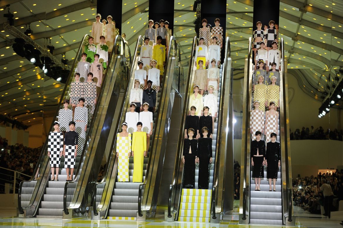 Teaming up with artist Daniel Buren for this set design, Marc Jacobs, who was the creative director for Louis Vuitton at the time, installed four escalators onto the runway of the Grand Palais in Paris. Buren's signature checkerboard pattern can be seen on the set as well as throughout the collection itself.
