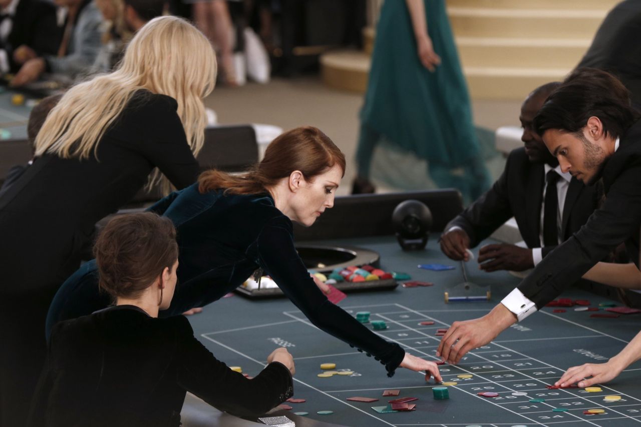 Hollywood starlets Kristen Stewart, Julianne Moore and Rita Ora opened for the show by taking center stage at casino tables. They then proceeded to play while models showed off the collection using the runway around them. 