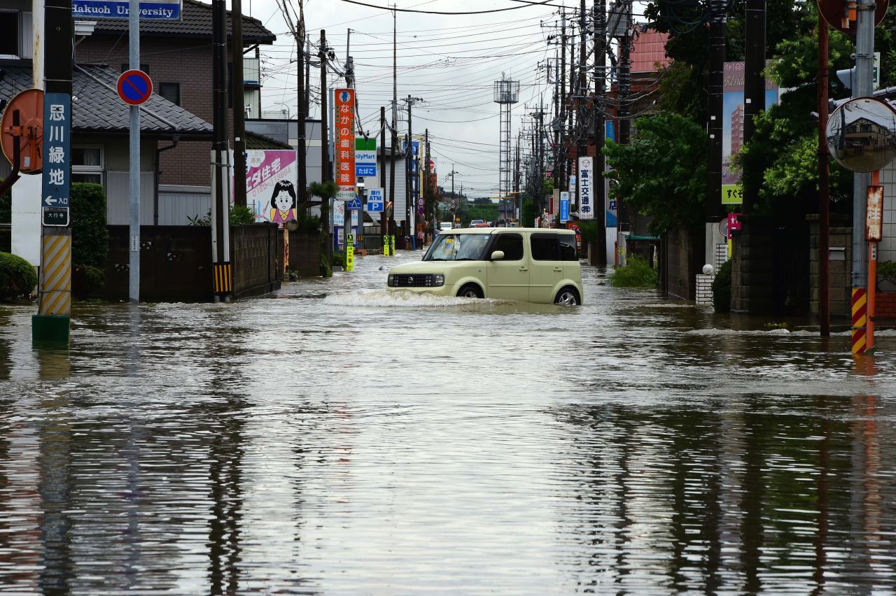 A car makes its way through a flooded street in Oyama on September 10.