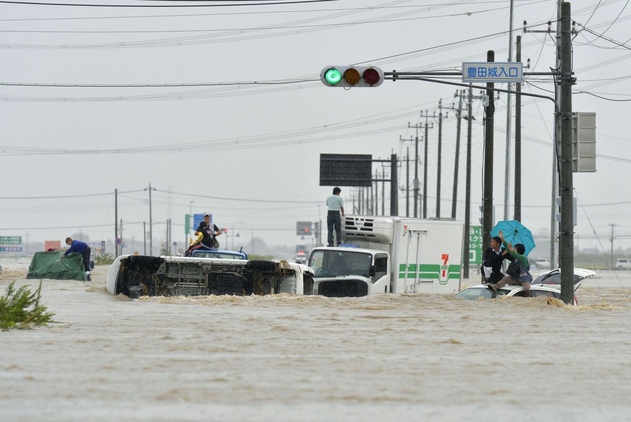 People await help while vehicles are overturned and submerged in Joso on September 10.