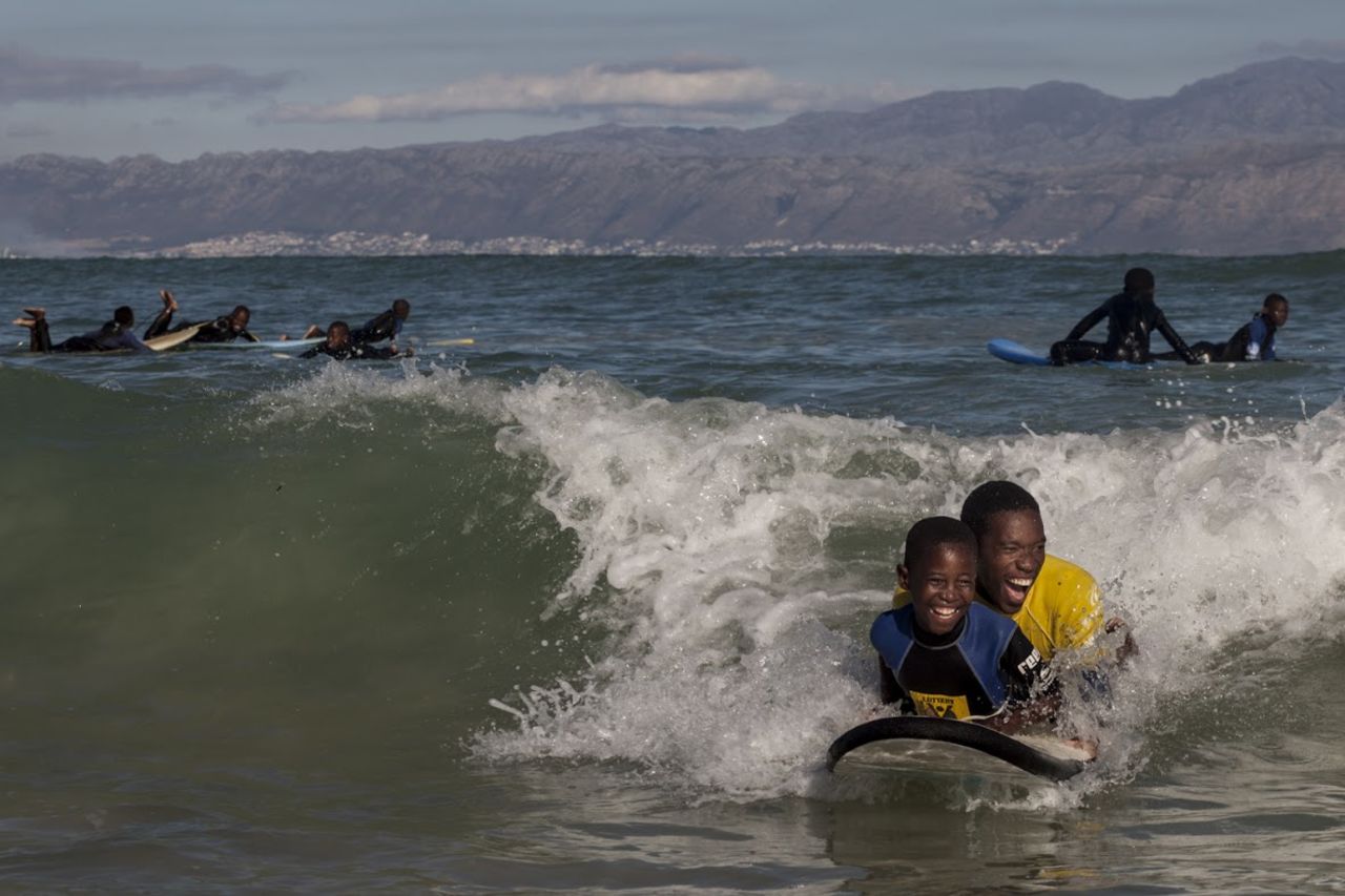 A key part of Waves for Change is building trust, which makes this a typical sight at a W4C site. Here, a W4C coach shares a wave with a participant.  