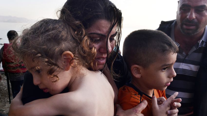 KOS, GREECE - AUGUST 15: A Syrian family arrives at a beach on the Greek island of Kos after crossing a part of the Aegean sea from Turkey to Greece in a dinghy on August 15, 2015 in Kos, Greece. The Greek government has sent a cruise ship to the island of Kos which will be able to house up to 2,500 refugees and operate as a registration centre, after 2,000 Syrian refugees were locked in an old stadium during a registration process and left without water for more than a day.  (Photo by Milos Bicanski/Getty Images)