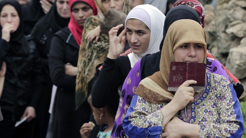 Syrian women wait in line to receive aid from an Islamic relief agency at a refugee camp in the town of Ketermaya, north of the port city of Sidon, Lebanon, Monday, Sept. 7, 2015. There are some 1.2 million registered Syrian refugees in Lebanon, many of them living in flimsy tents scattered across the country. (AP Photo/Bilal Hussein)