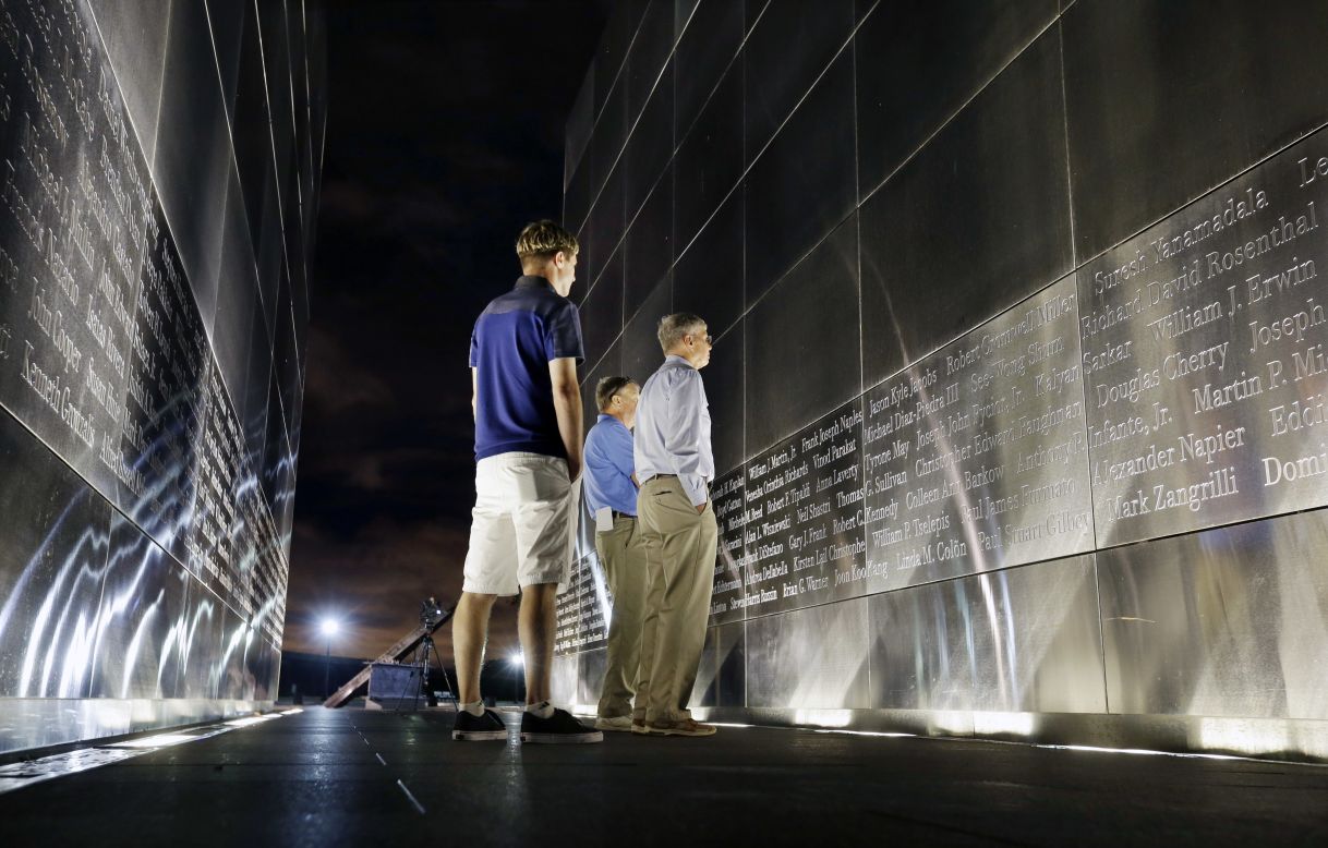 Terry Miller, right, and Chris Miller, center, look for the name of their brother Robert Cromwell Miller at the Empty Sky memorial to New Jersey's victims of 9/11. The memorial is in Jersey City across the Hudson River from the World Trade Center site. Nephew James Miller, left, joins them Friday.