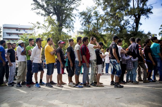 Long queues form as refugees wait to receive food in a park near the port of Mytilini, Lesbos. Many arrive wet, hungry and tired after paying huge amounts of money to risk their lives on small, crowded boats.