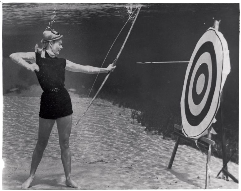 Even for an image such as this one, Mozert and his team tested materials and props underwater before taking the photograph. "They tested the effect of the current on the arrow as it left the archer's bow -- she had to hit the target. No air hoses are visible in these photographs (with slight exception, they were not used). Silver Springs required something else -- the illusion of verity was key."