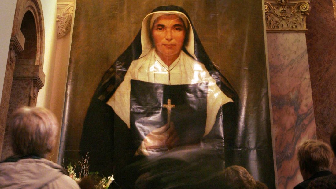 After a mass to celebrate the canonization of <strong>St. Mother Theodore Guerin</strong>, visitors look at the portrait of the French-born 19th-century nun at the Sisters of Providence of St. Mary-of-the-Woods in Terre Haute, Indiana, in 2006. She is best known for founding schools in Illinois and throughout Indiana. She is the patron saint of Indianapolis. 