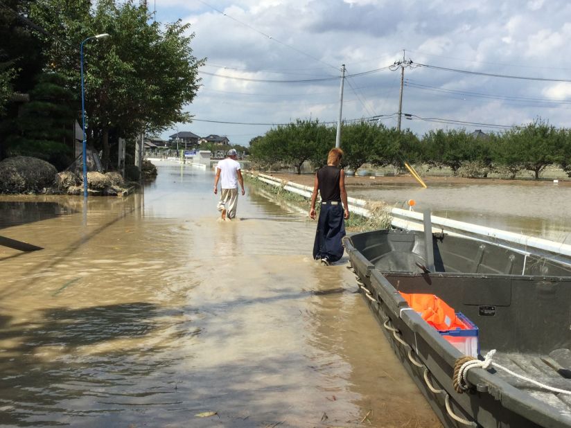 Men walk along a flooded road near Joso City, Japan on September 12. 