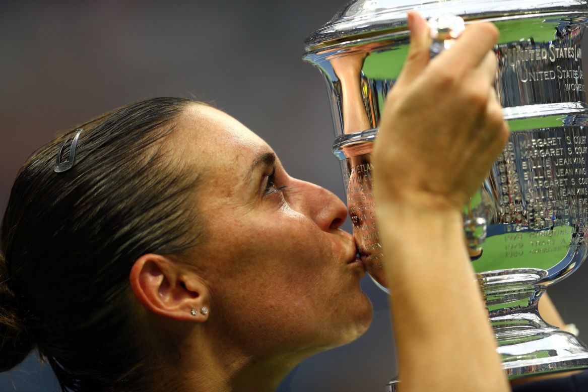 Flavia Pennetta celebrates with the winner's trophy after beating Roberta Vinci 7-6 6-2 in the final at Flushing Meadows.
