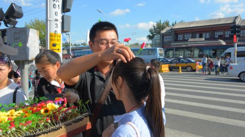 Excited tourists try on hair clips in Nanluoguxiang, a popular tourist spot in Beijing.