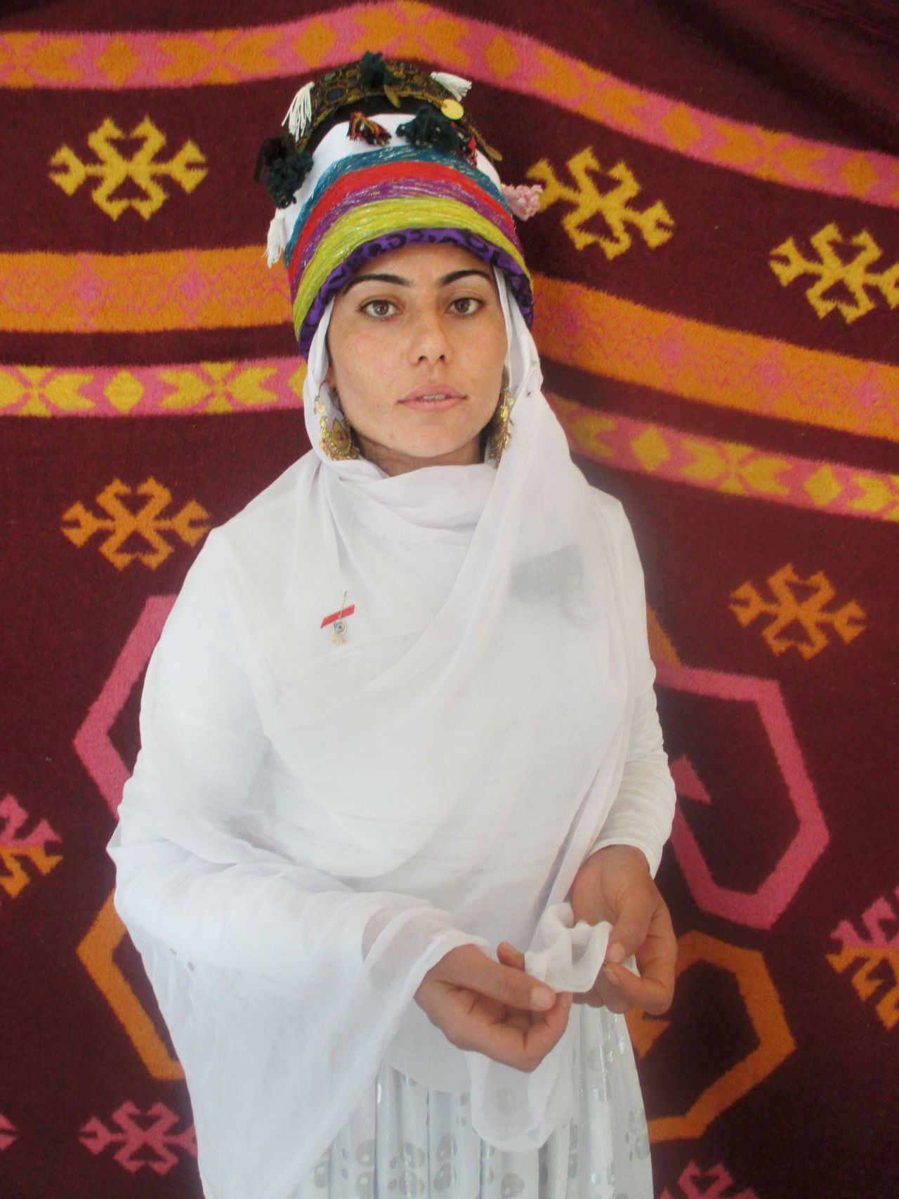 18-year-old Barfi's photography project focused on traditional Yazidi dress. She took portraits of friends and relatives against colorful backdrops in her camp. This is her sister wearing celebratory clothing. 
