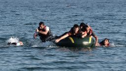 Syrian migrants paddle their dinghy to the shores of the Greek island of Kos on August 17, 2015 after their small engine broke down as they motored across the sea from Turkey.  Authorities on the island of Kos have been so overwhelmed that the government sent a ferry to serve as a temporary centre to issue travel documents to Syrian refugees -- among some 7,000 migrants stranded on the island of about 30,000 people. The early hours are the safest time for migrants travelling from Turkey to the Greek islands just across the water, which have seen a huge influx of refugees escaping the civil war in Syria and chaos in Afghanistan since the beginning of this year.