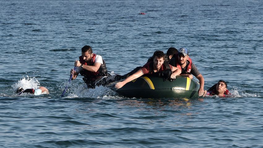 Syrian migrants paddle their dinghy to the shores of the Greek island of Kos on August 17, 2015 after their small engine broke down as they motored across the sea from Turkey. Authorities on the island of Kos have been so overwhelmed that the government sent a ferry to serve as a temporary centre to issue travel documents to Syrian refugees -- among some 7,000 migrants stranded on the island of about 30,000 people. The early hours are the safest time for migrants travelling from Turkey to the Greek islands just across the water, which have seen a huge influx of refugees escaping the civil war in Syria and chaos in Afghanistan since the beginning of this year.