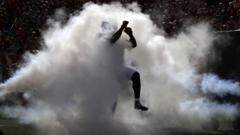 Vincent Jackson, a wide receiver for the NFL's Tampa Bay Buccaneers, jumps through smoke during team introductions in Tampa, Florida, on Sunday, September 13.