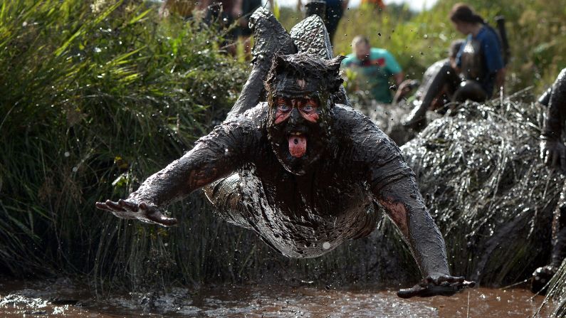 A competitor jumps into a pool of mud as he takes part in the Mud Madness charity race in Portadown, Northern Ireland, on Sunday, September 13. 