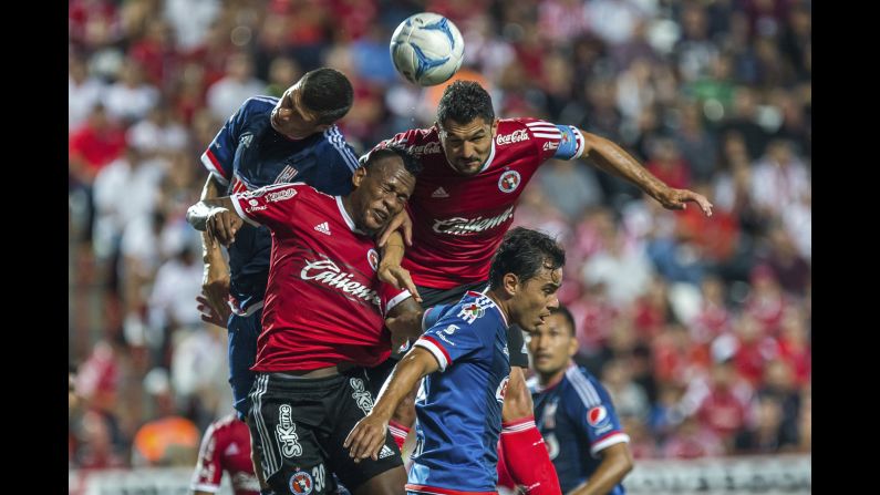 Players from Tijuana and Chivas jump for a header during a league match in Tijuana, Mexico, on Friday, September 11.