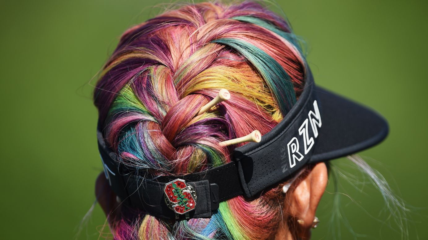Golf tees sit in Michelle Wie's colorful hair as she practices for the Evian Championship on Wednesday, September 9.