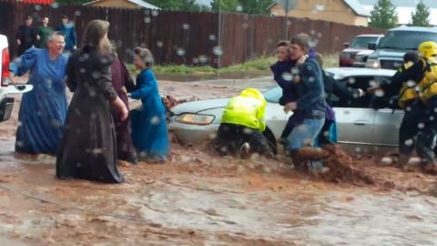 Rescuers try to help those stuck in a submerged car in Hildale, Utah. 