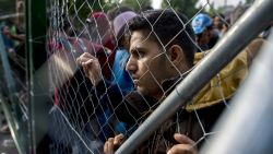 A migrant looks through a fence at the closed Roszke-Horgos border crossing at the border between Hungary and Serbia near Horgos, Serbia, Tuesday, Sept.15, 2015. (Tamas Soki/MTI via AP)