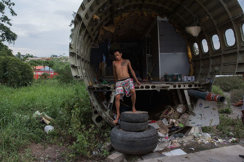 Unable to make enough money to rent a home, three Thai families apparently live in the field's disused airplanes. 