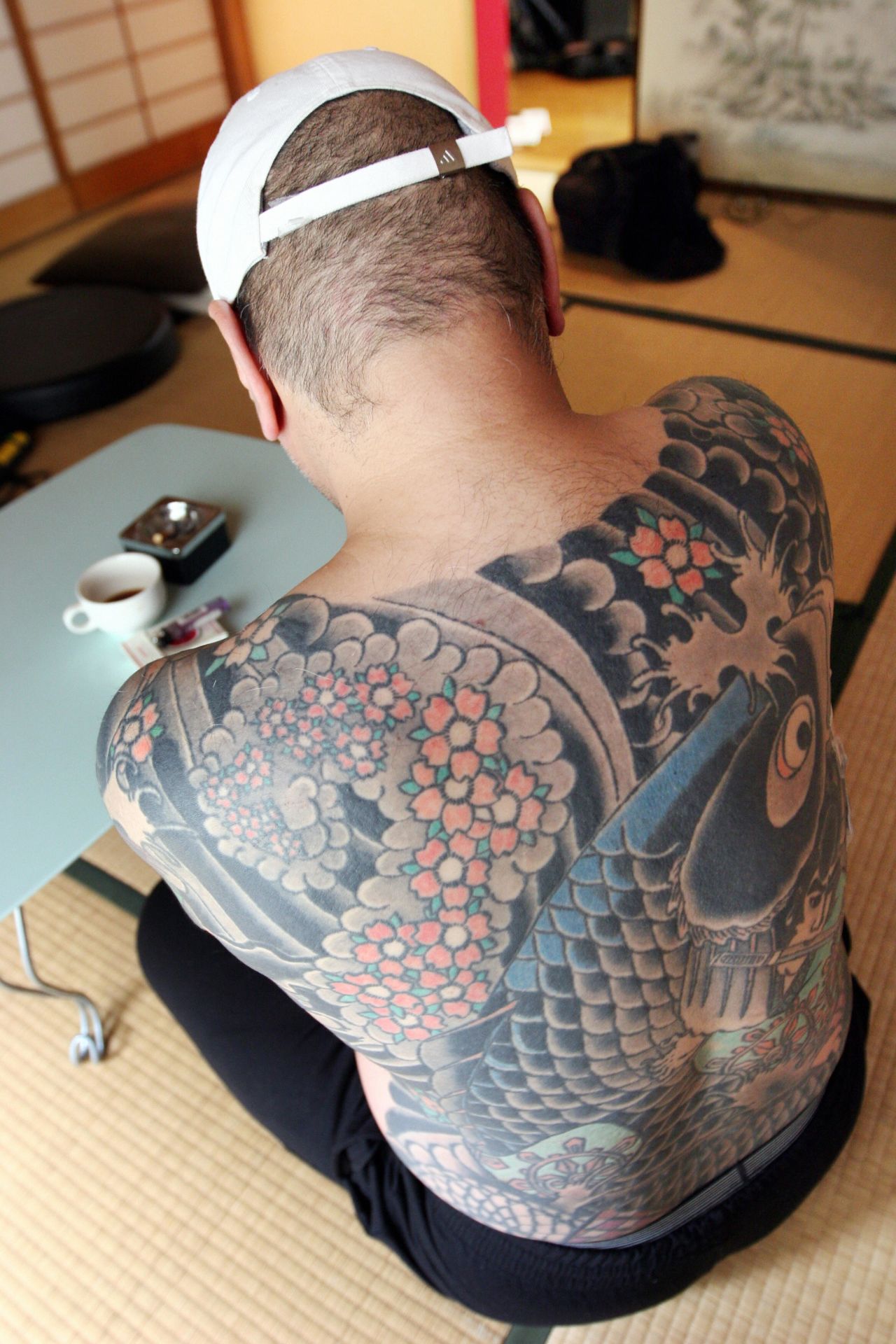 A retired yakuza boss, who does not wish to be identified, is pictured at his residence in Tokyo in 2009. His tattoo on his back features a carp swimming upstream against a waterfall.
