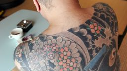 A retired Japanese yakuza crime boss, who does not want to be identified, shows his tattoo on his back, featuring a carp swimming up a waterfall at his residence in Tokyo on March 20, 2009. Japan's mafia are being squeezed by the steepest economic downturn in decades, and as profits have plunged, management has been thinning out the ranks.
