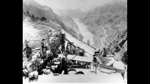 Workers in 1932 construct a retaining wall to support the road leading over the top of the dam. Before the dam could be built, the government had to create a town, Boulder City, to house construction workers; build a seven-mile paved highway from Boulder City to the dam site; and construct 33 miles of railroad from the Union Pacific main line in Las Vegas.