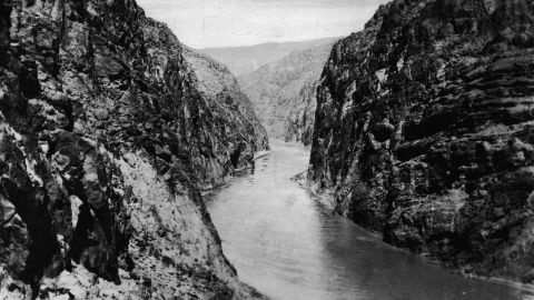 This image shows Black Canyon on the Colorado River before work started. During construction, the water was diverted around the dam site through four 50 feet in diameter tunnels, drilled through the canyon walls on each side of the river. Damming of the river created Lake Mead, now a popular recreation spot for boaters.