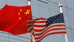 Beijing, CHINA: A US and a Chinese flag wave outside a commercial building in Beijing, 09 July 2007. US Secretary of State Condoleezza Rice 06 July 2007 accused China of flouting the rules of global trade in its headlong economic expansion as the US administration "has not been hesitant" to deploy trade tools against China, including a complaint lodged with the World Trade Organization over copyright piracy. AFP PHOTO/TEH ENG KOON (Photo credit should read TEH ENG KOON/AFP/Getty Images)