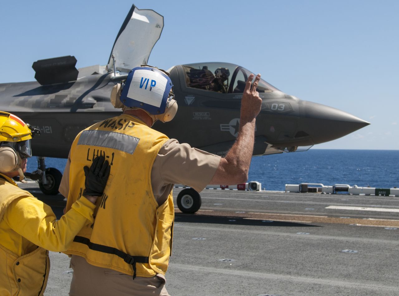 Vice Adm. William Hilrides, commander of Naval Sea Systems Command, holds up two fingers to indicate to the F-35B Lightning II pilot to power up for takeoff aboard the amphibious assault ship the amphibious assault ship USS Wasp in May.