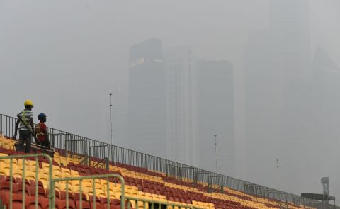 Workers install seats by part of the Formula One street circuit  for the night Singapore Grand Prix, which takes place on September 20, as a haze shrouds the city skyline. Organizers say the event will go ahead, with air quality forecast to improve in time.