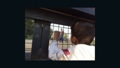 A migrant child in Serbia gazes through the gate to Hungary.