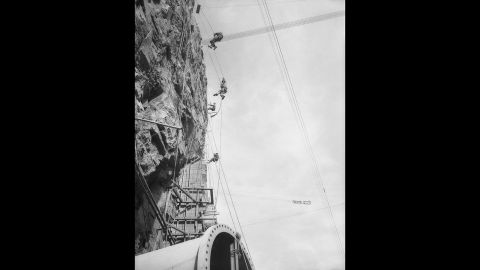 Workers rappel down a rock face during construction, which was often hazardous. A total of 21,000 men worked on the dam. Of those, 96 died at the dam site from falls, drowning, blasting, falling rocks, being struck by heavy equipment, truck accidents and other causes, according to the Bureau of Reclamation.