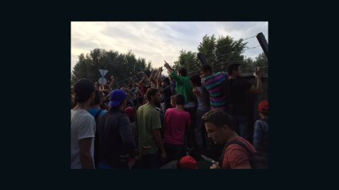 Migrants gathered at the Serbian-Hungarian border chant, "Open, open."