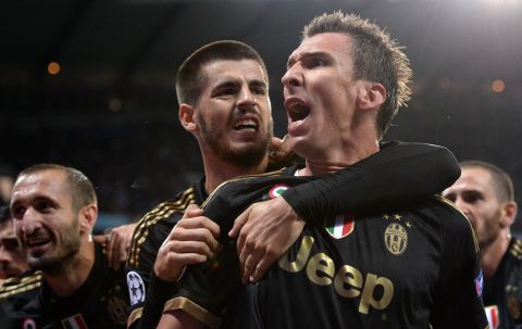 Juventus forward Mario Mandzukic (C) celebrates with Alvaro Morata (L) after scoring during a UEFA Champions League group stage football match between Manchester City and Juventus at the Etihad stadium in Manchester. Juventus won the match 2-1.