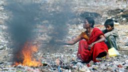 Hyderabad, INDIA: An Indian mother and her son burn waste in order to retrieve the copper wire at the garbage dump in the Borabanda slum in Hyderabad, 05 June 2007, on the occasion of World Environment Day. World Environment Day, commemorated each year 05 June, is one of the principal vehicles through which the United Nations stimulates worldwide awareness of the environment and enhances political attention and action.   AFP PHOTO / NOAH SEELAM (Photo credit should read NOAH SEELAM/AFP/Getty Images)