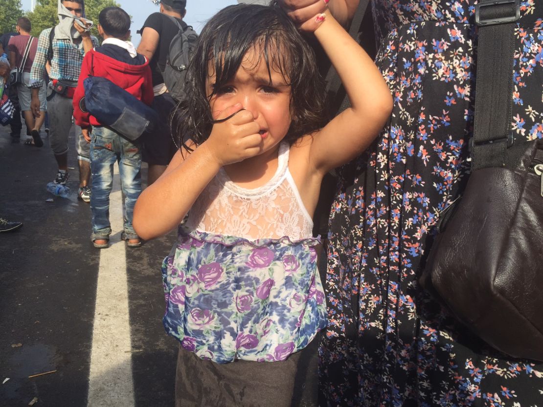 A girl cries after Hungarian police use tear gas and water cannons on migrants at the border. 