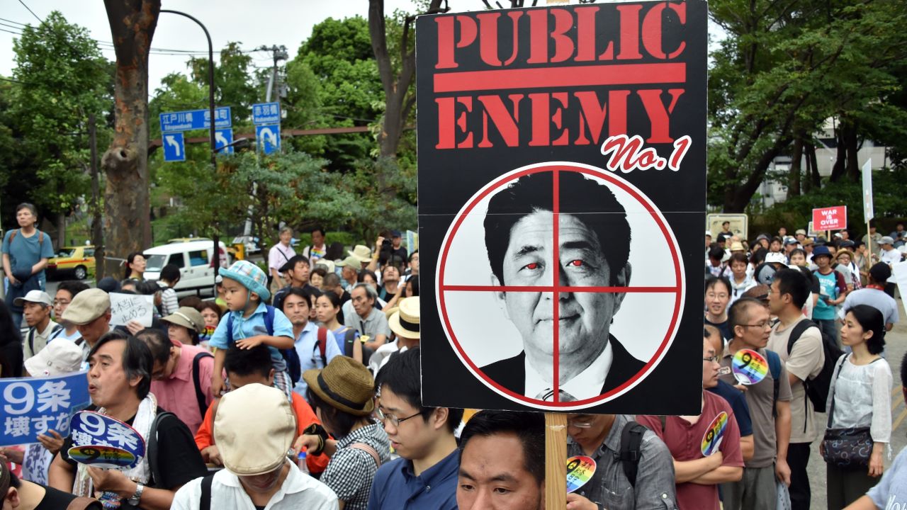 Civic group members hold placards during an anti-government rally in Tokyo on August 23, 2015.