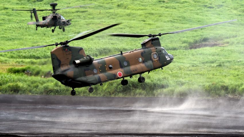 A CH-47J Chinook heavy lift helicopter, escorted by an AH-64DJP Apache attack helicopter (top L), prepares to land Japanese Ground Self-Defense Force troops during an annual live fire exercise at the Higashi-Fuji firing range in Gotemba, at the foot of Mount Fuji in Shizuoka prefecture on August 18, 2015. The annual drill involves some 2,300 personnel, 80 tanks and armoured vehicles and some 20 aircraft and helicopters.   AFP PHOTO / Toru YAMANAKA        (Photo credit should read TORU YAMANAKA/AFP/Getty Images)