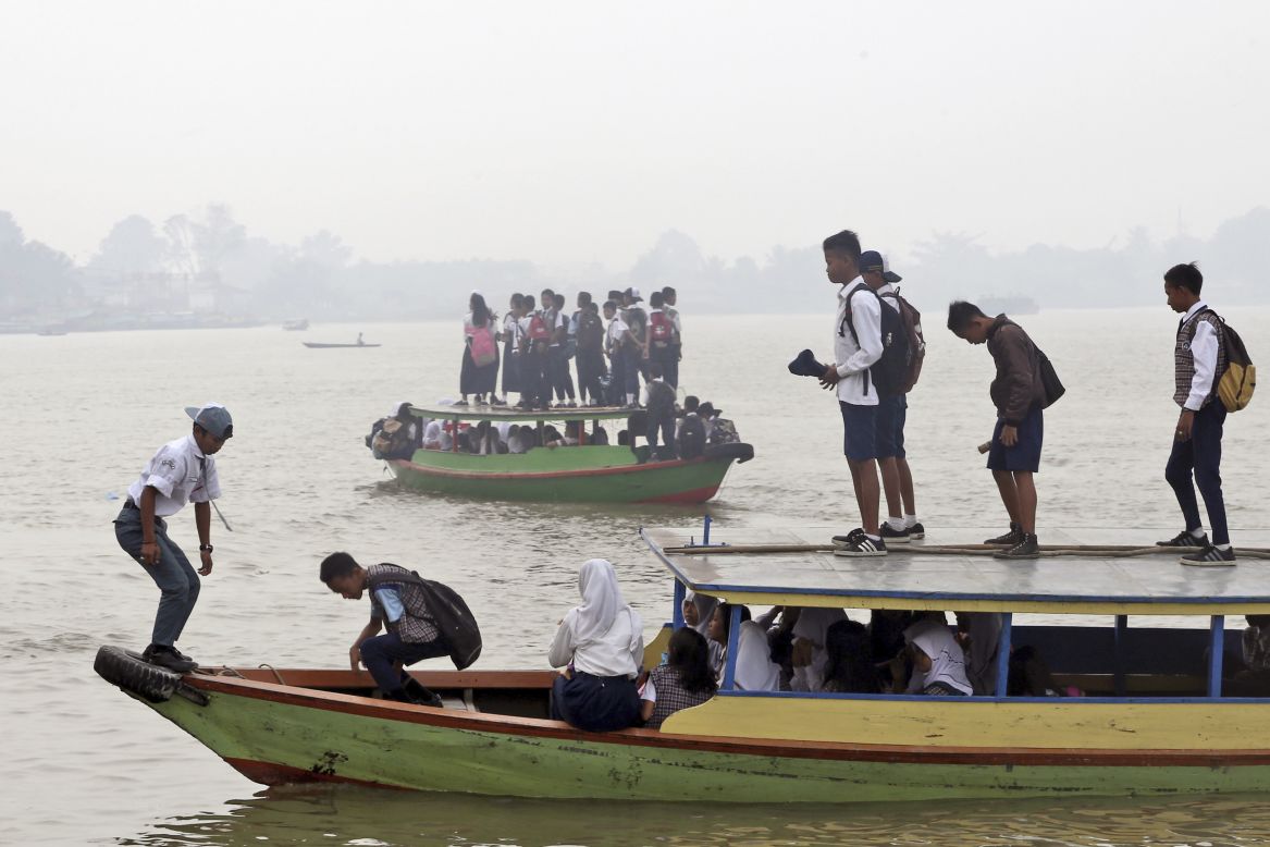 Students commute to school on boats while haze from agricultural and forest fires blankets the Ogan River in Palembang, South Sumatra, Indonesia on September 15, 2015. The thick haze caused by fires from illegal land clearing on Indonesia's Sumatra and Borneo islands spreads over to Singapore and Malaysia.