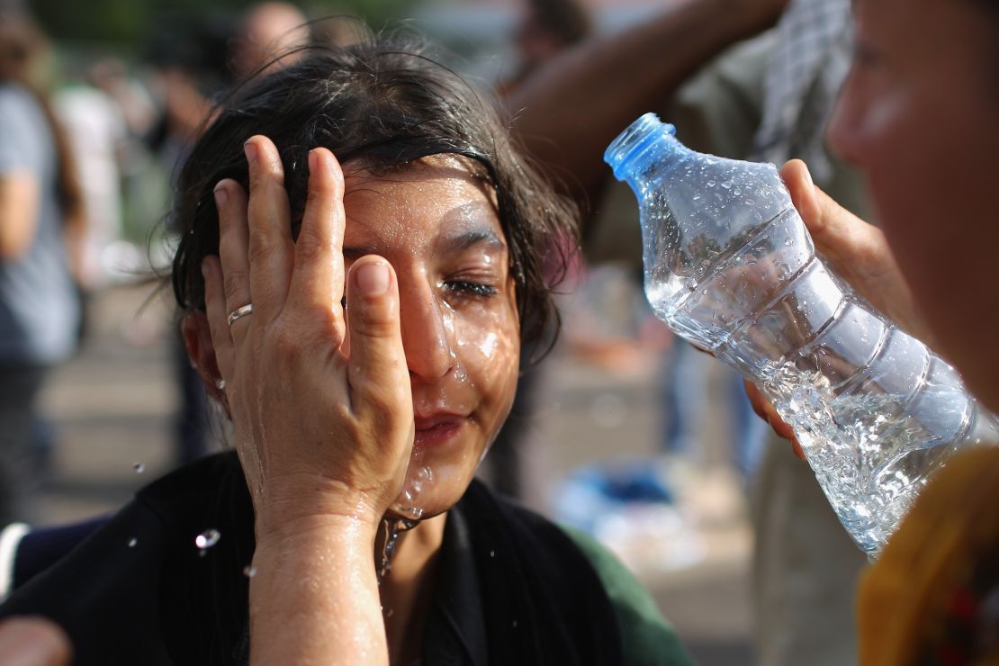 A migrant girl has stinging chemicals washed from her eyes Wednesday in Horgos, Serbia. 