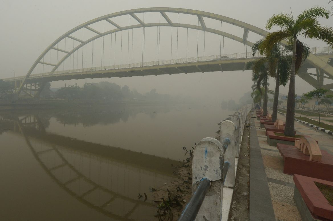 Cars drive through a bridge over the Siak river in Riau, Indonesia, on September 13, 2015. Indonesia declared a state of emergency in Sumatra's Riau province on September 14 as air quality hit a very dangerous level with an API exceeding 900.